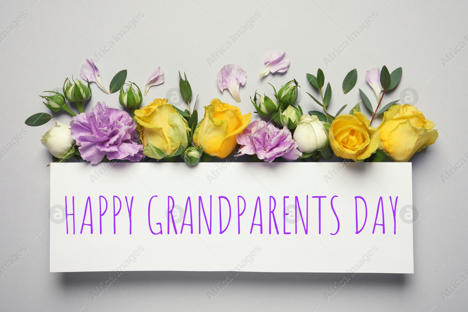 Image of Flat lay composition with beautiful blooming flowers and phrase HAPPY GRANDPARENTS DAY on grey background