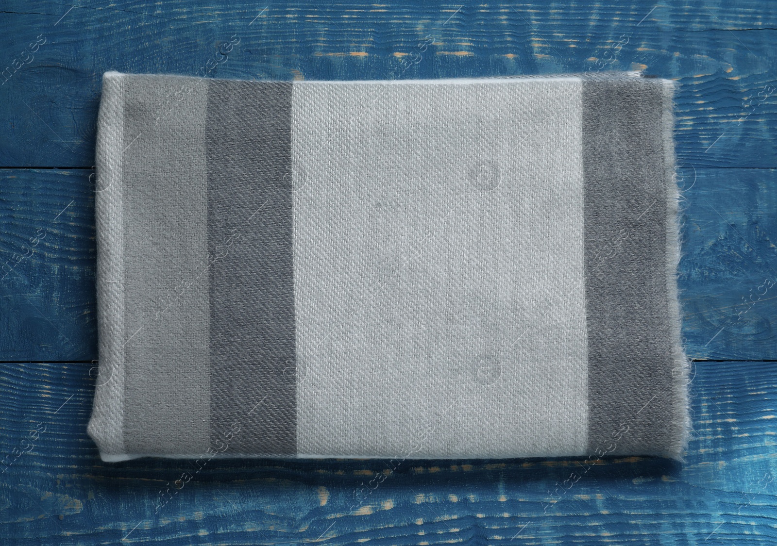 Photo of Soft scarf on blue wooden table, top view