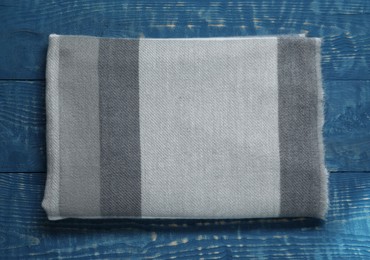 Photo of Soft scarf on blue wooden table, top view