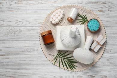 Photo of Composition of herbal bags and spa products on white wooden table, top view. Space for text