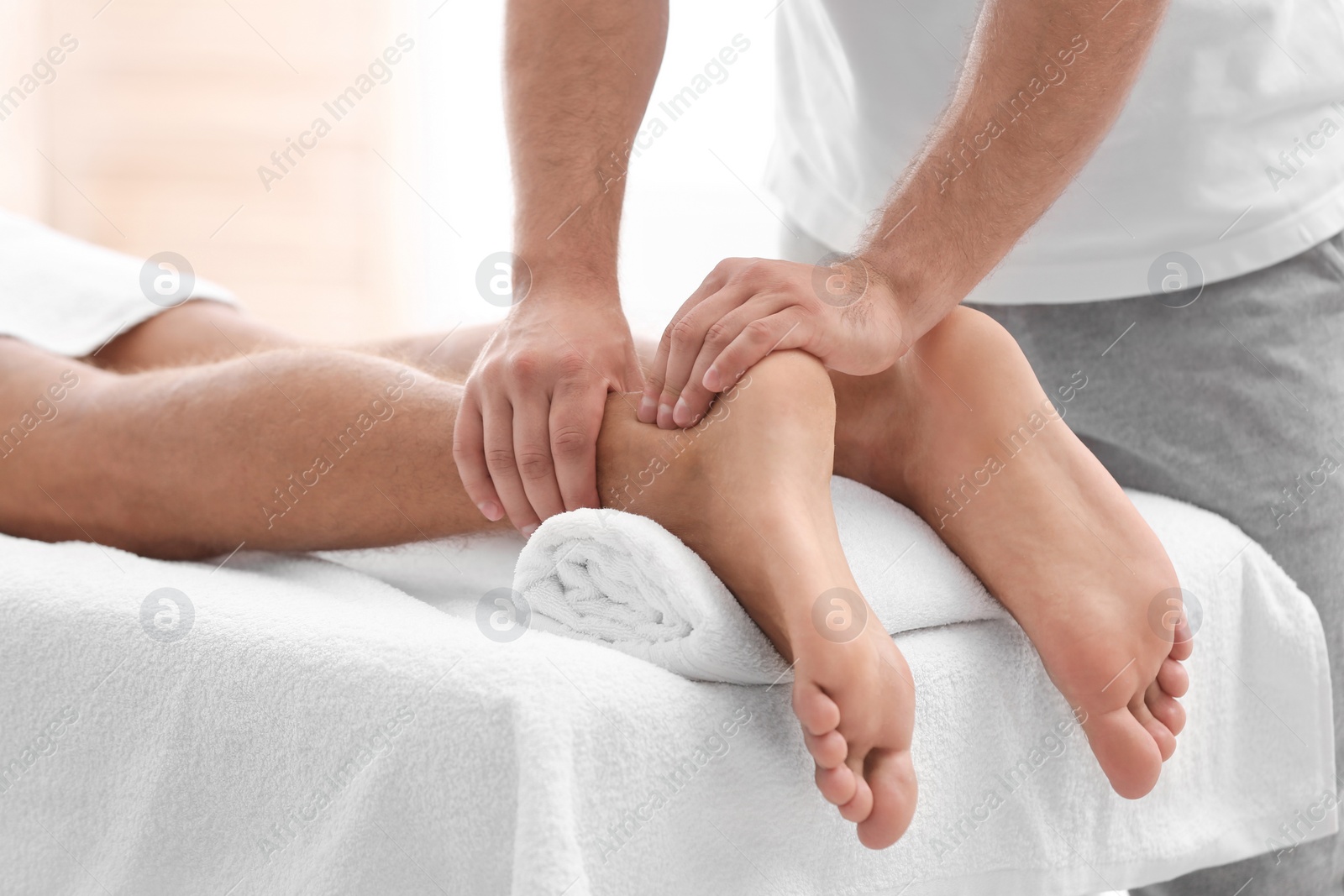 Photo of Young woman receiving massage in salon, closeup