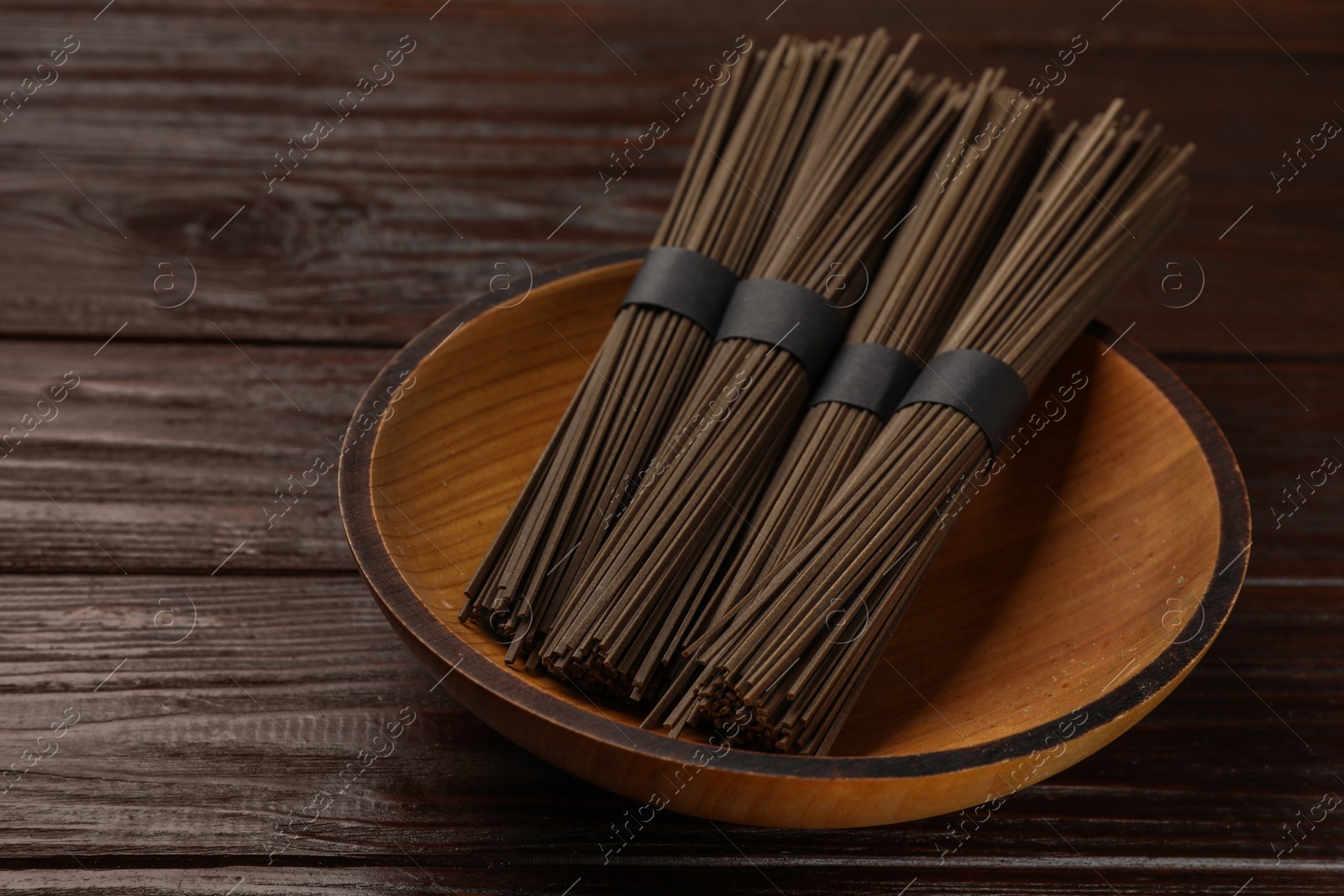 Photo of Uncooked buckwheat noodles (soba) on wooden table