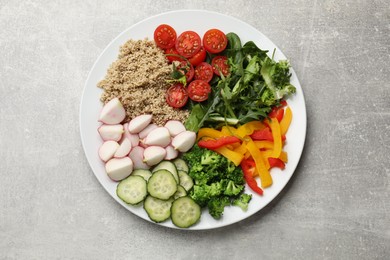 Photo of Vegetarian diet. Plate with tasty vegetables and quinoa on light grey table, top view