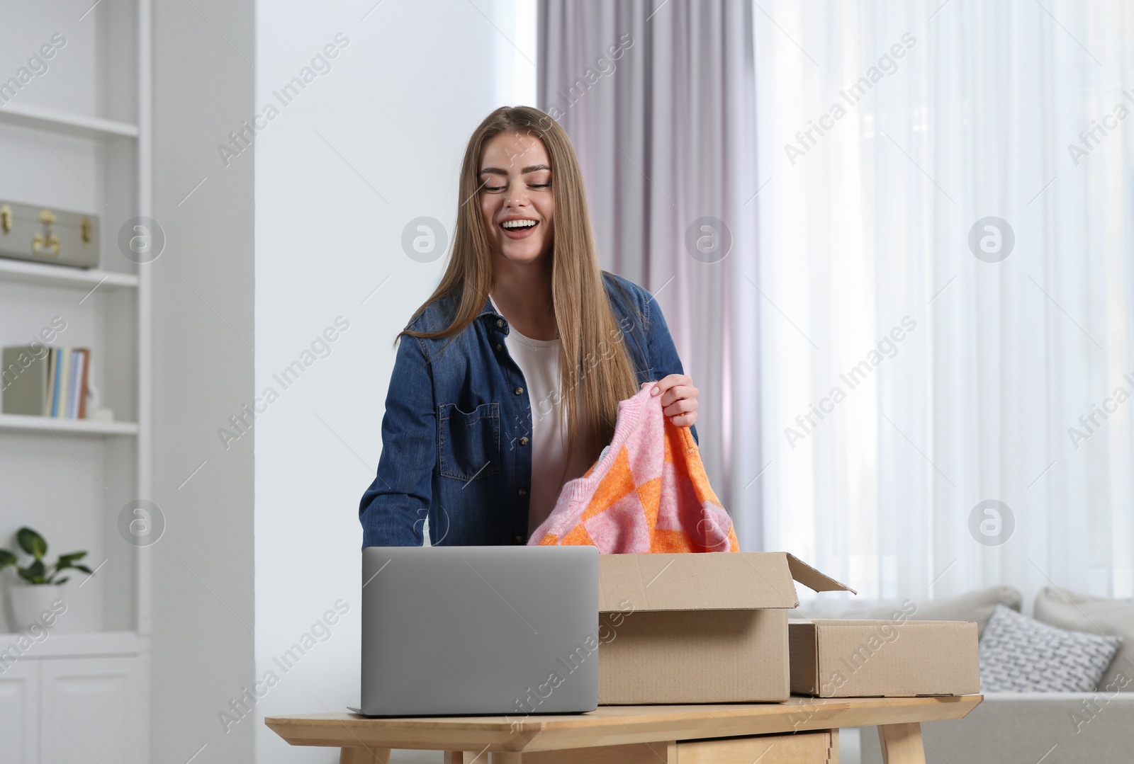 Photo of Happy woman unpacking parcel at home. Online store