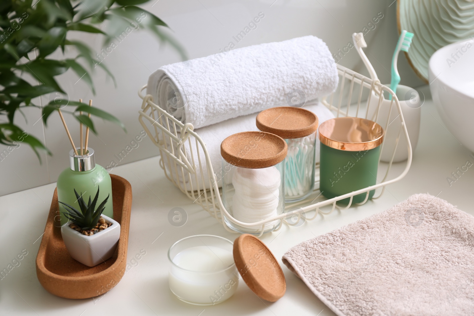 Photo of Personal hygiene products on table near white wall in bathroom