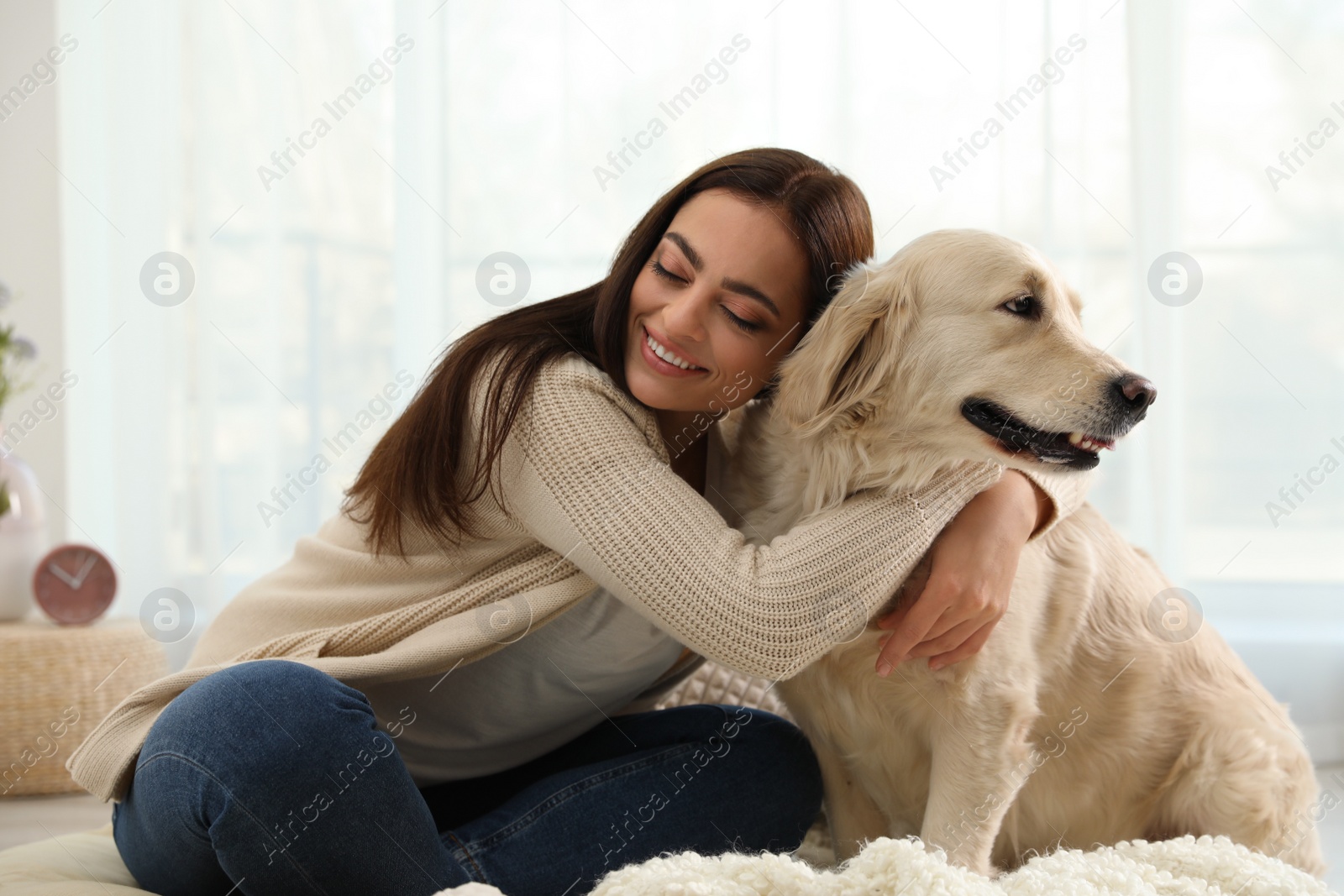 Photo of Young woman and her Golden Retriever at home. Adorable pet