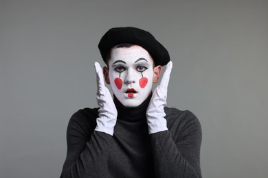 Photo of Mime artist in beret posing on grey background