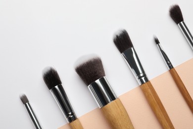 Set of makeup brushes on color background, flat lay. Space for text