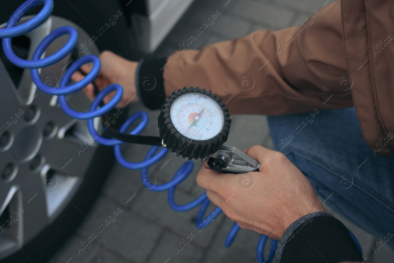 Photo of Man inflating tire at car service, closeup