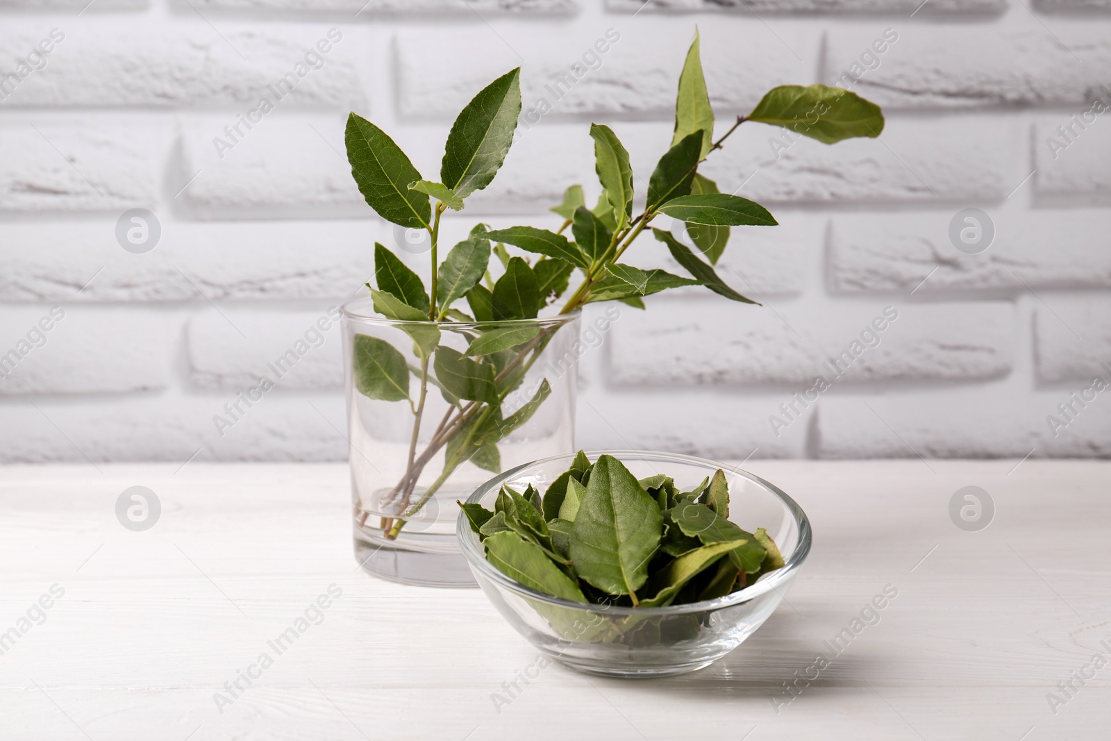 Photo of Fresh green bay leaves on white wooden table