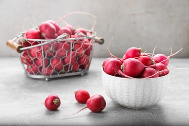 Photo of Bowl and metal basket with fresh ripe radishes on grey table