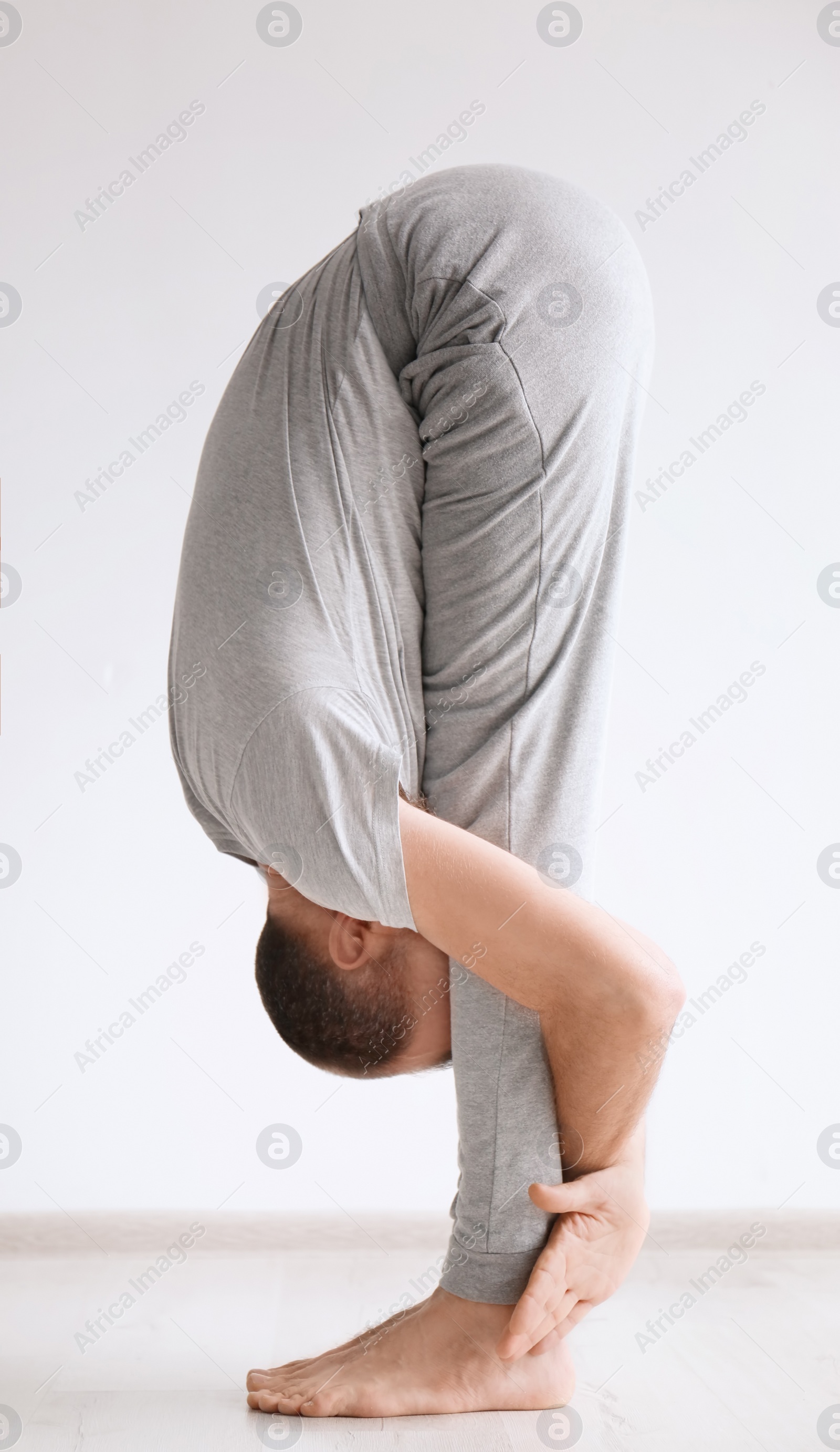 Photo of Sporty man practicing yoga indoors