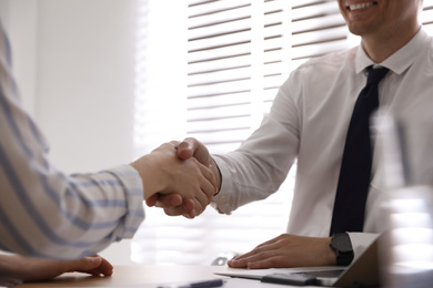 Photo of Business people shaking hands in office, closeup