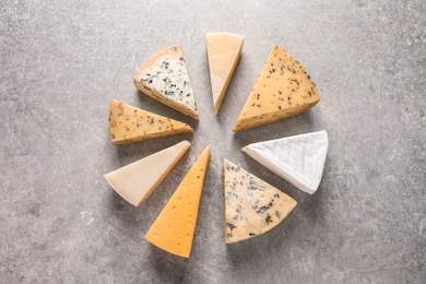 Photo of Flat lay composition with different kinds of cheese on grey background