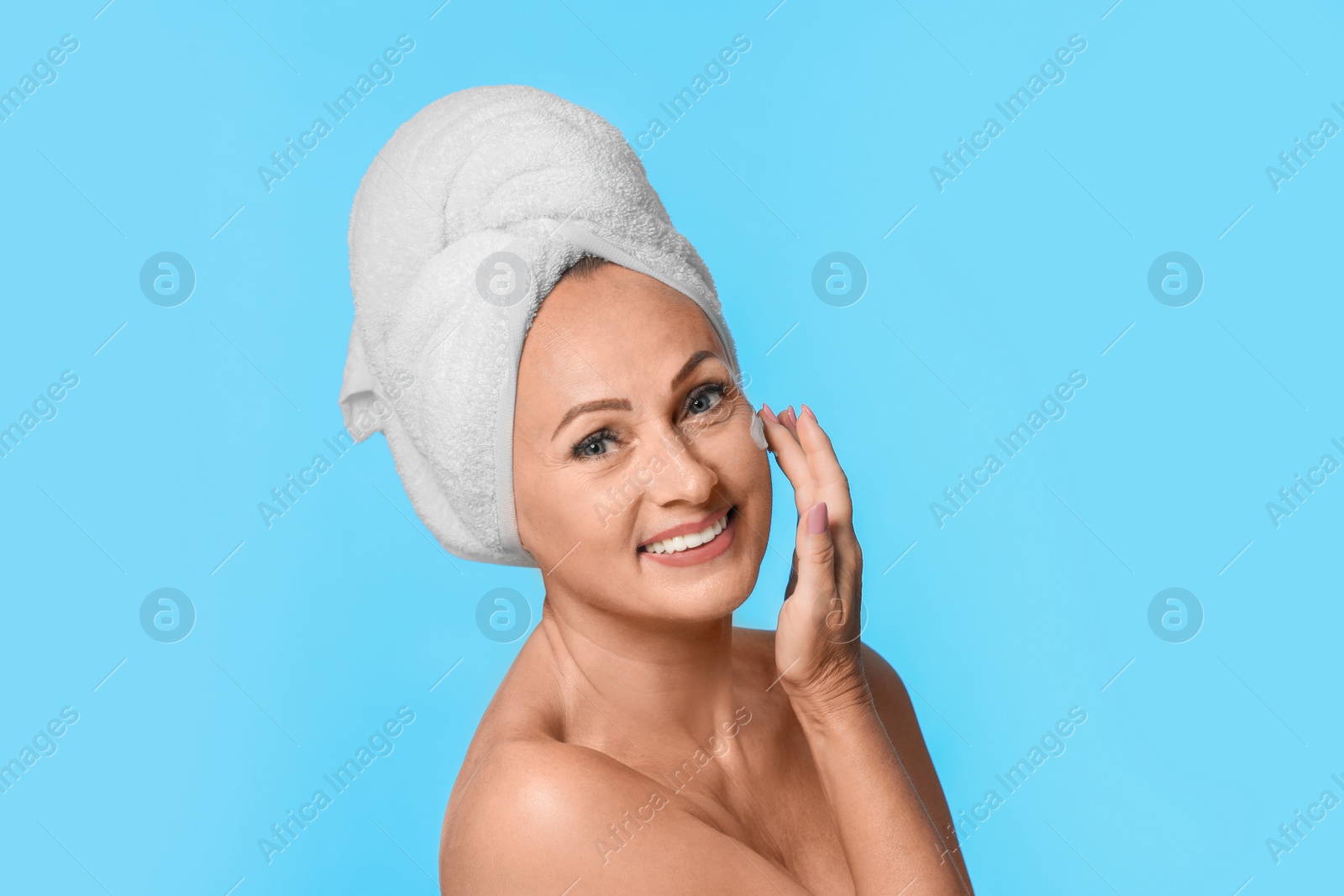 Photo of Portrait of beautiful mature woman with perfect skin on light blue background