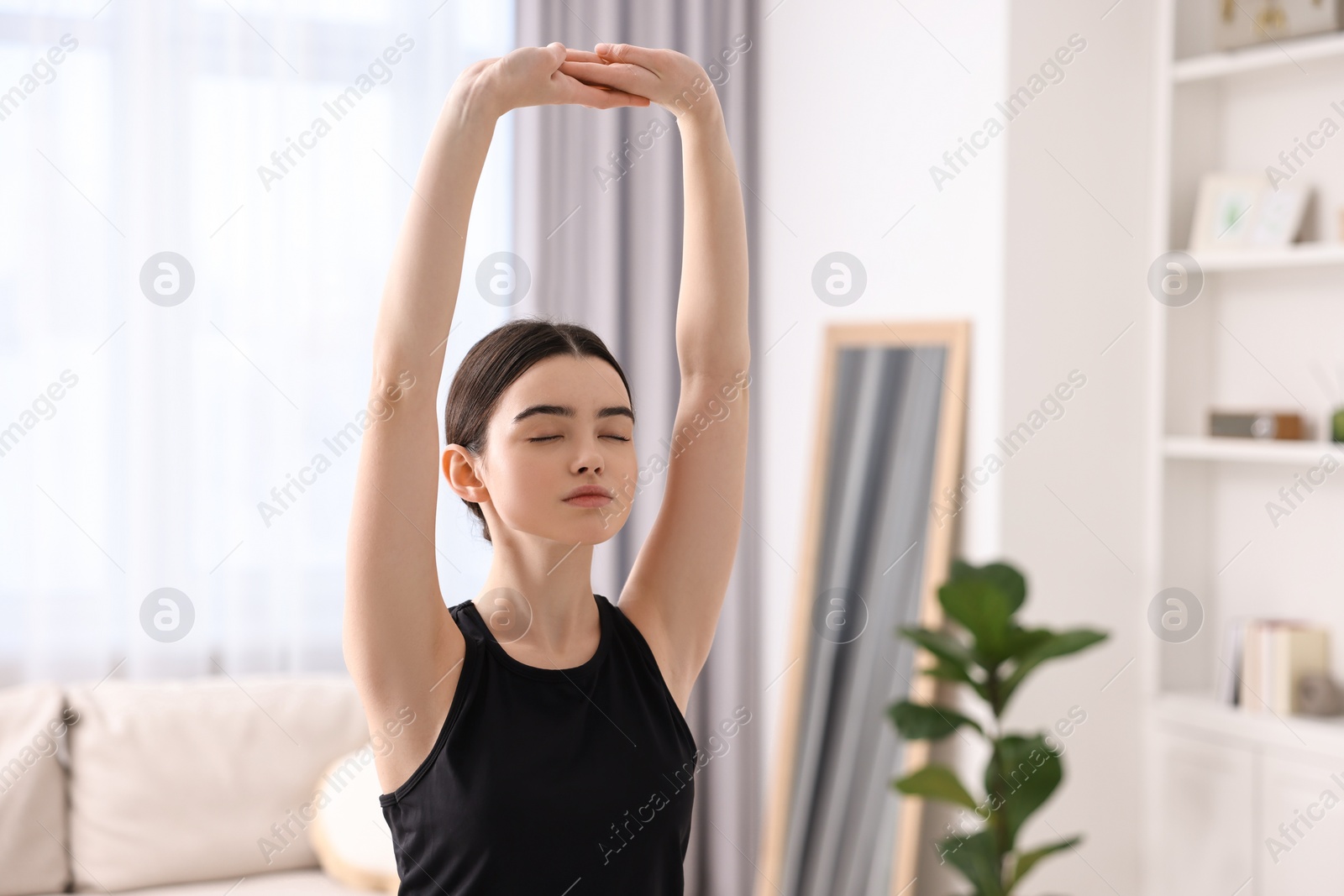 Photo of Portrait of beautiful girl practicing yoga at home