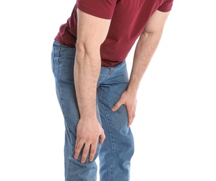 Young man suffering from leg pain on white background, closeup