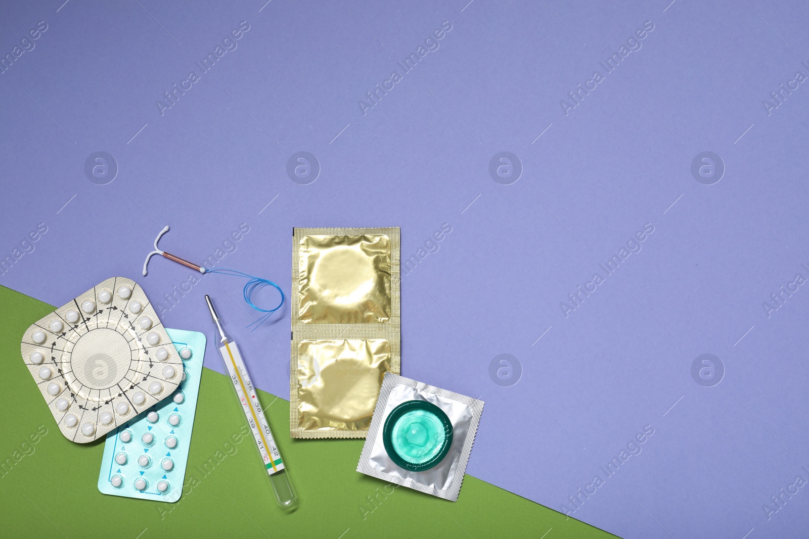 Photo of Contraceptive pills, condoms, intrauterine device and thermometer on color background, flat lay with space for text. Choice of birth control method