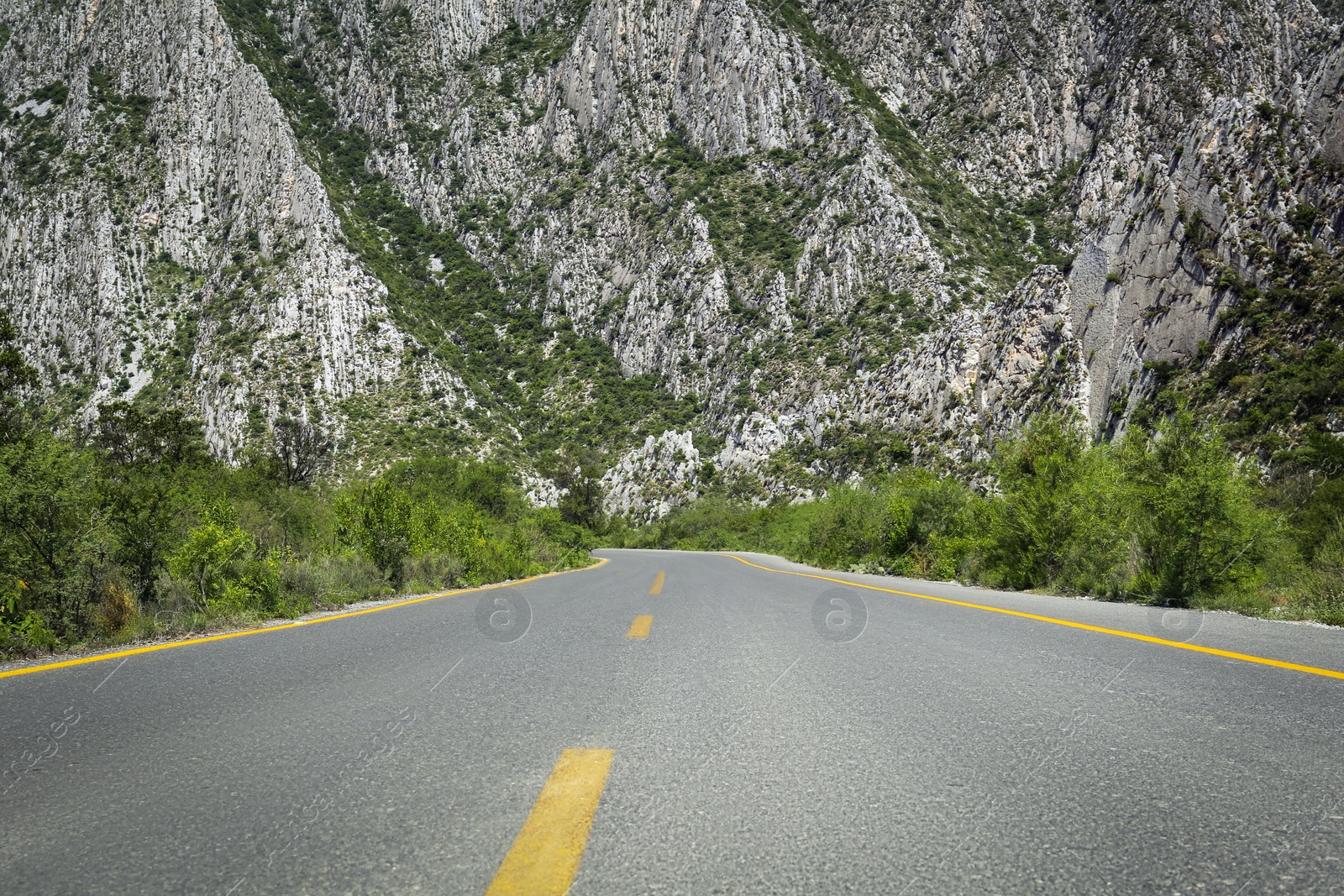 Photo of Picturesque view of big mountains and bushes near road