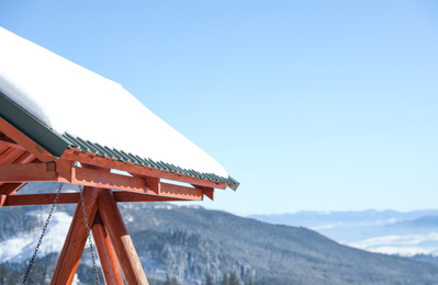 Photo of Wooden gazebo covered with snow in mountains. Winter vacation