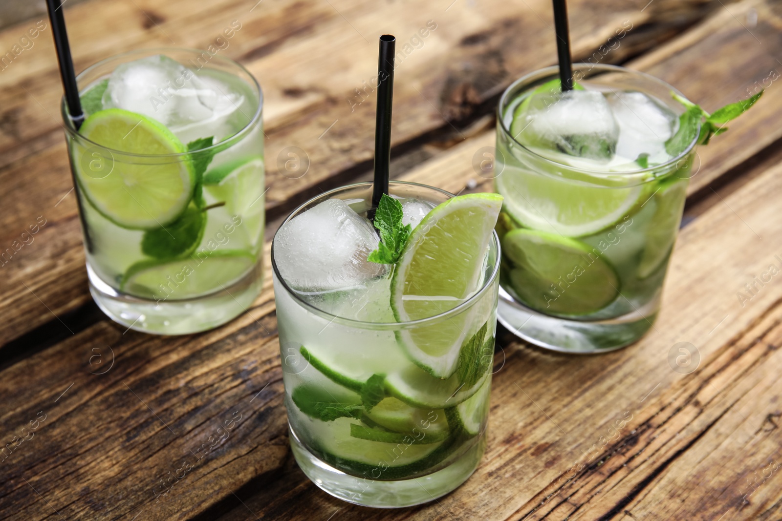 Photo of Delicious mojito and ingredients on wooden table