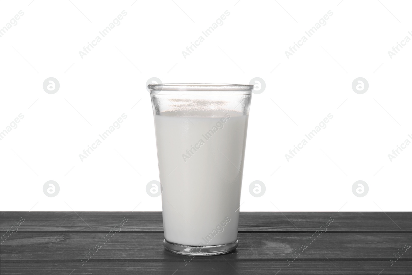 Photo of One glass of tasty milk on blue wooden table against white background