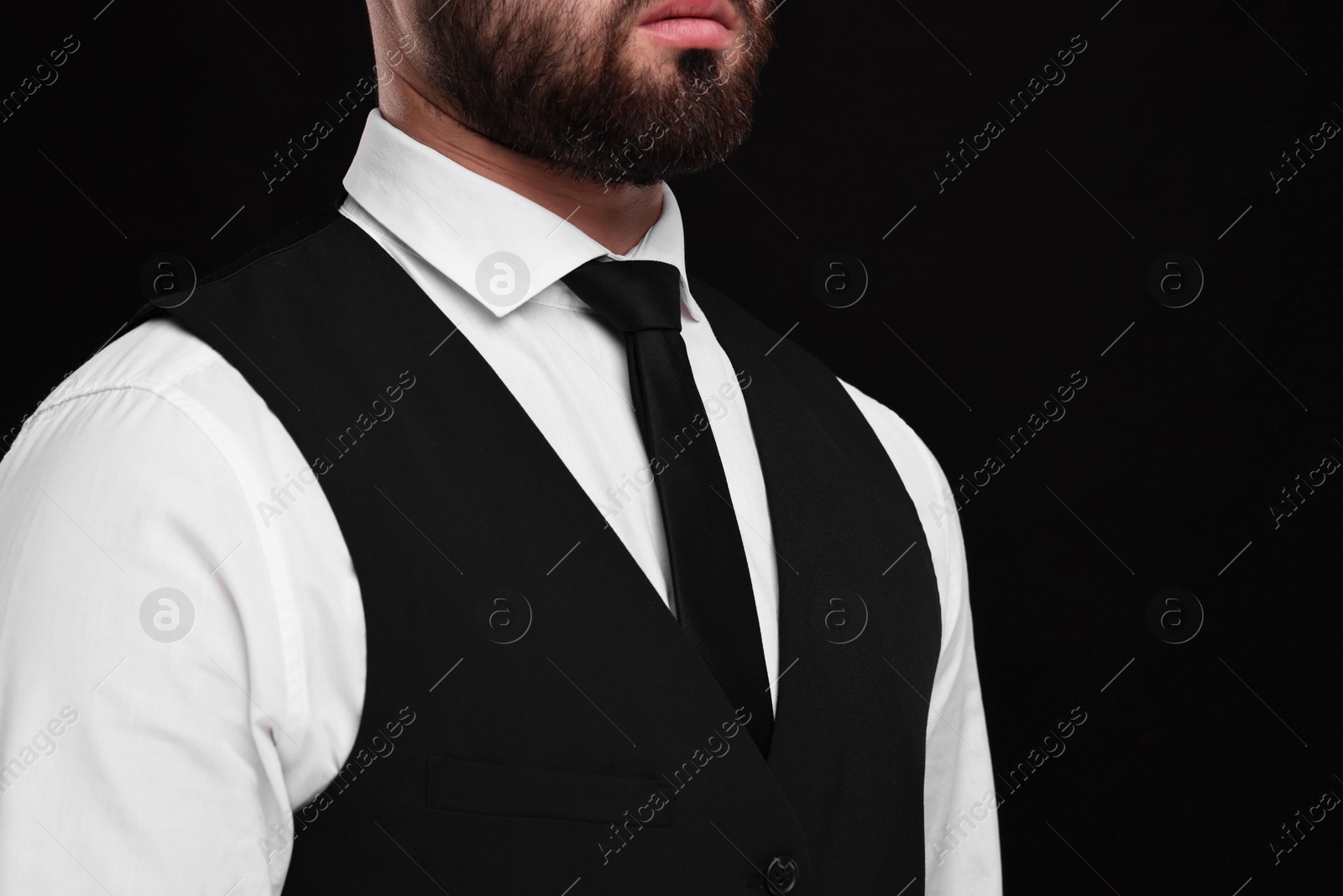 Photo of Businessman in shirt and necktie on black background, closeup