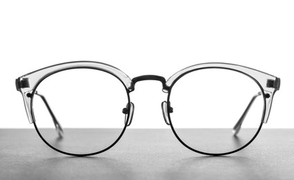 Photo of Stylish glasses on table against white background