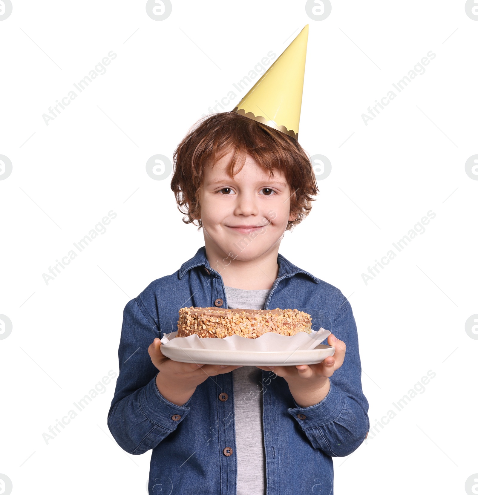 Photo of Birthday celebration. Cute little boy in party hat holding tasty cake on white background