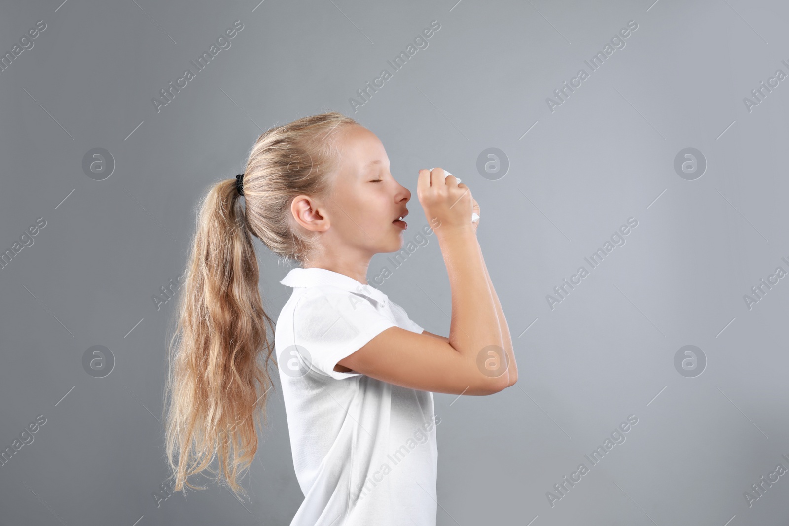 Photo of Little girl suffering from allergy on grey background