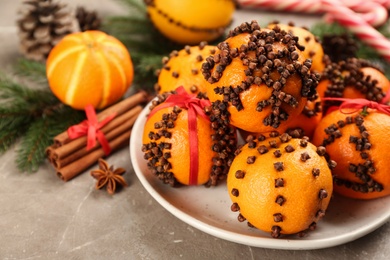 Photo of Pomander balls made of fresh tangerines and cloves grey table, space for text
