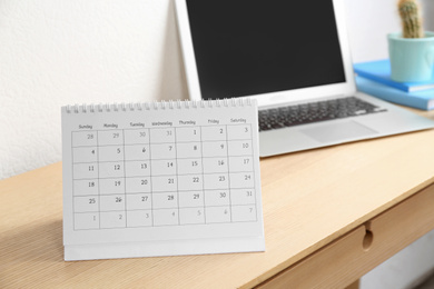 Paper calendar on wooden table in office