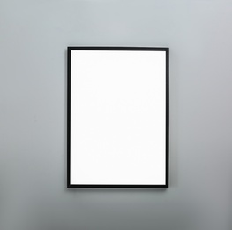 Frame with empty canvas on wall in modern art gallery. Mockup for design