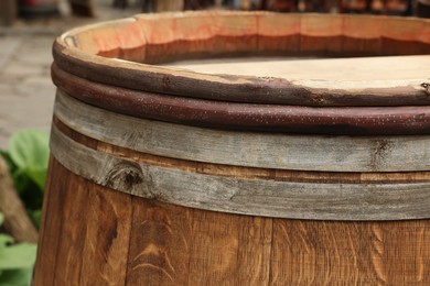 Photo of Traditional wooden barrel on street outdoors, closeup. Wine making
