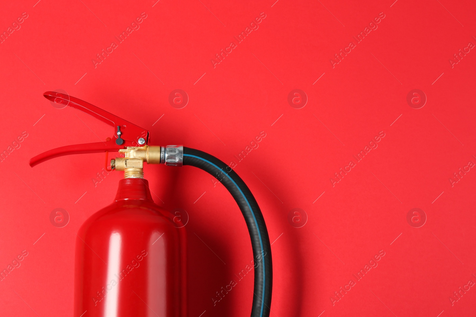 Photo of Fire extinguisher on red background, top view. Space for text