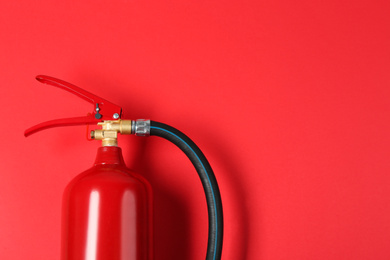 Fire extinguisher on red background, top view. Space for text