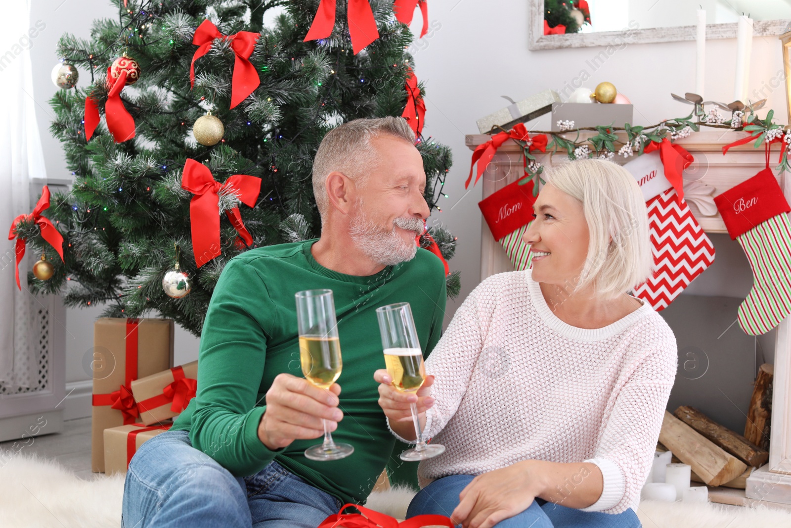 Photo of Mature couple with glasses of champagne at home. Christmas celebration