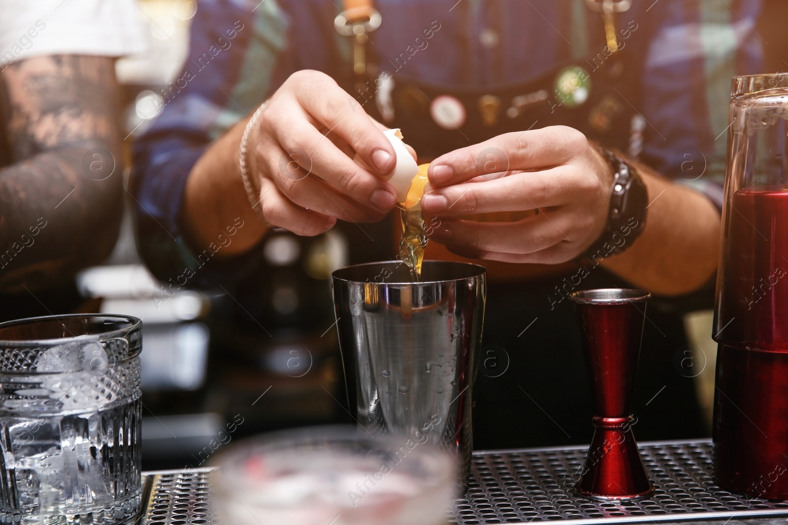 Photo of Bartender preparing tasty cocktail at counter in nightclub, closeup