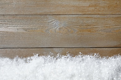 Photo of Snow and space for text on wooden background, top view. Christmas time