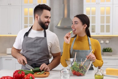 Photo of Lovely young couple cooking together in kitchen