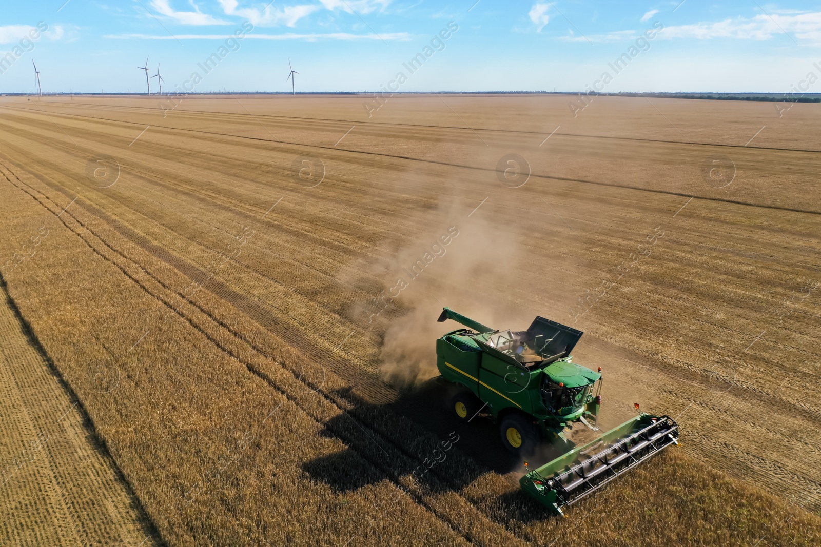 Photo of Modern combine harvester working in field on sunny day. Agriculture industry