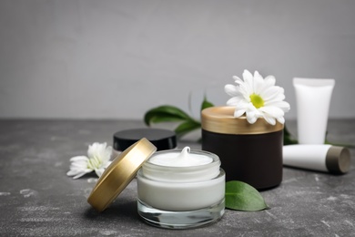 Photo of Composition with body cream in jars on grey background
