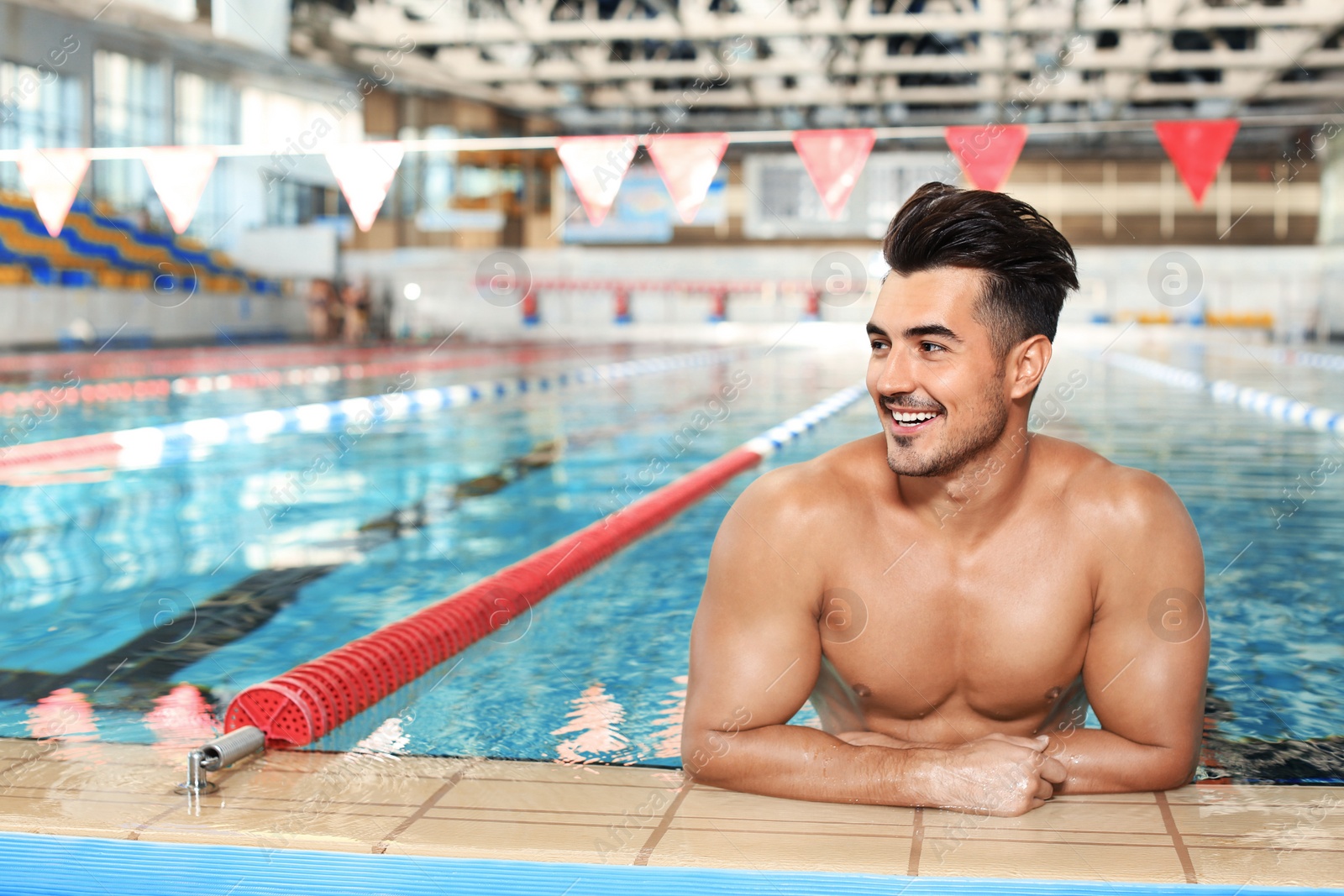 Photo of Young athletic man in swimming pool indoors