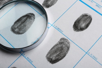 Magnifying glass and criminal fingerprint card, closeup