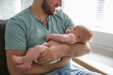 Photo of Father with his newborn son at home, closeup