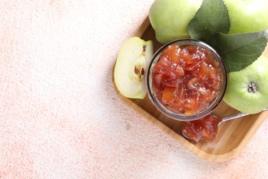 Photo of Glass jar of delicious apple jam and fresh fruits on light table, top view. Space for text