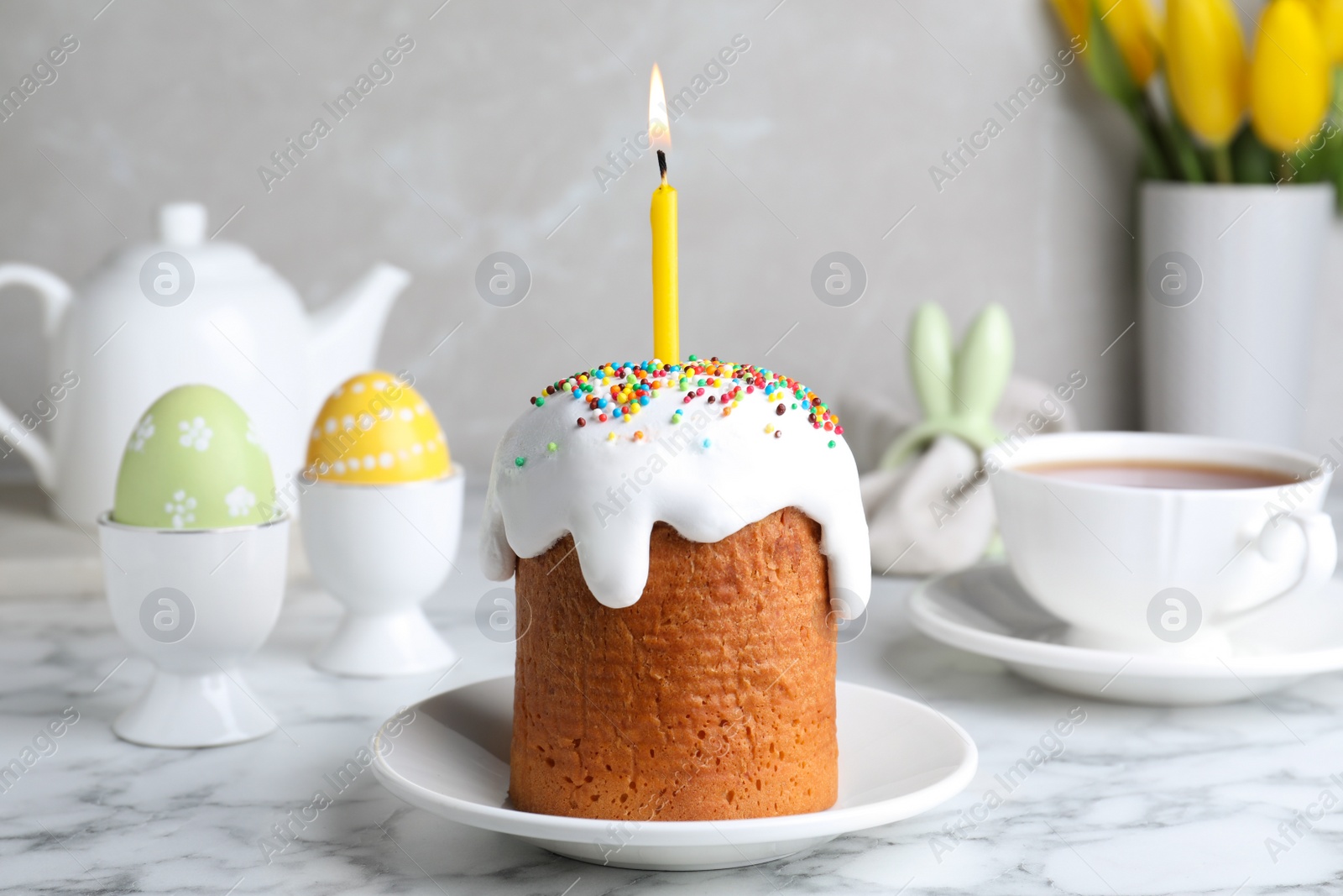 Photo of Beautiful Easter cake with candle on white marble table