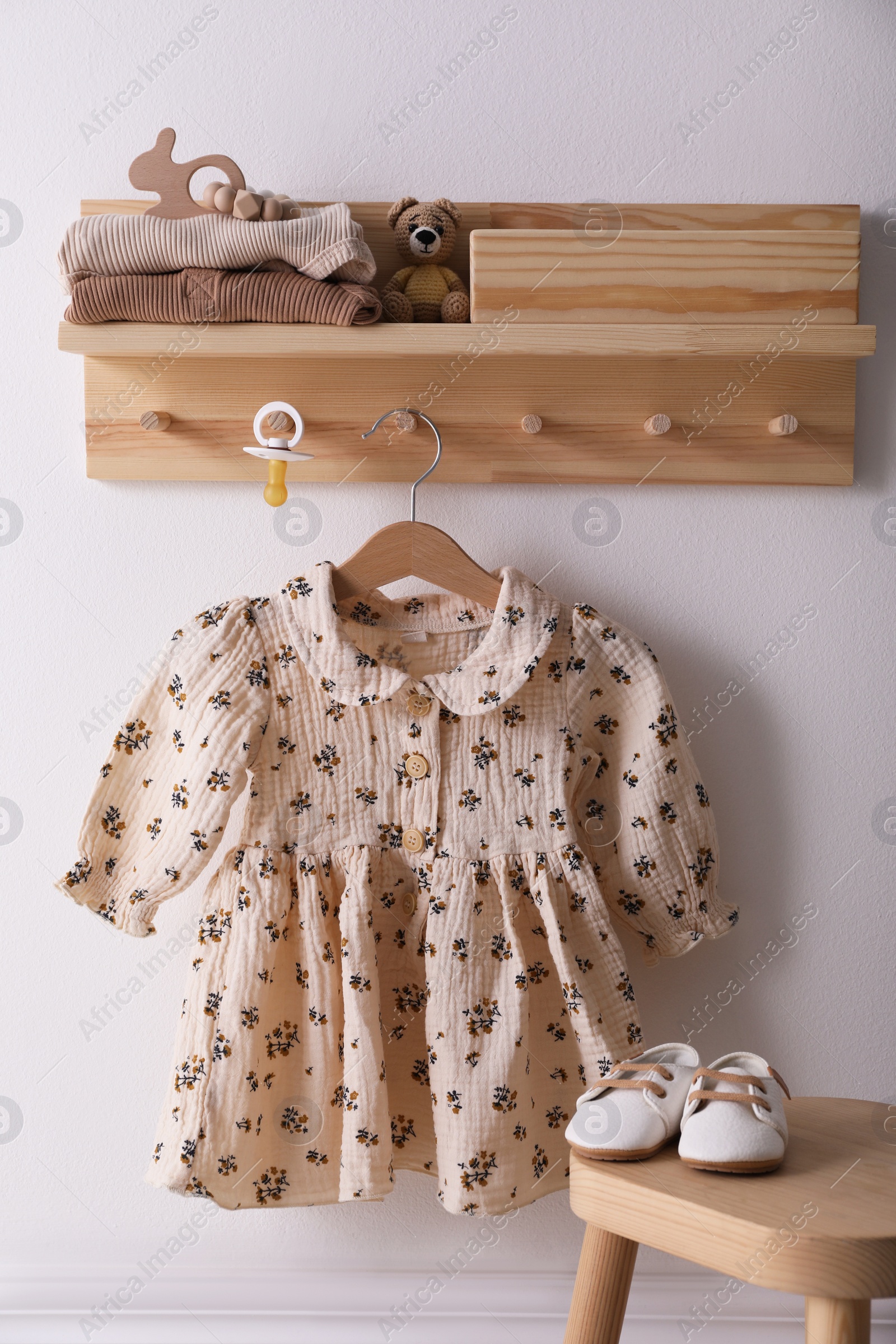 Photo of Cute children's clothes and shoes in room