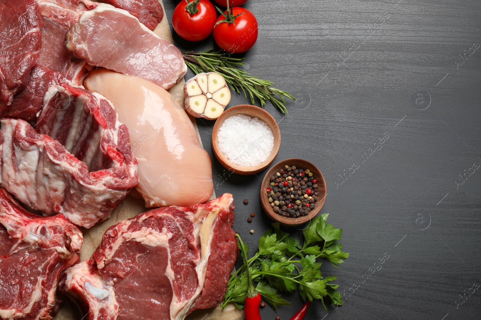 Photo of Flat lay composition with fresh meat on dark table