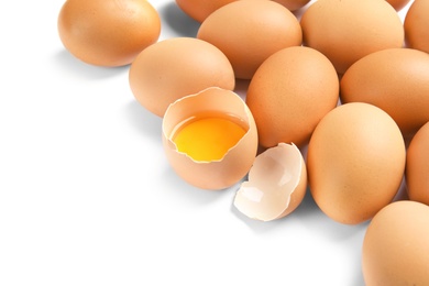 Photo of Cracked and whole chicken eggs on white background